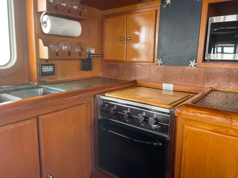 Slide: The Image of Galley kitchen in 2002 Transpacific Marine EAGLE 53 yacht with wooden cabinetry and appliances. - 14
