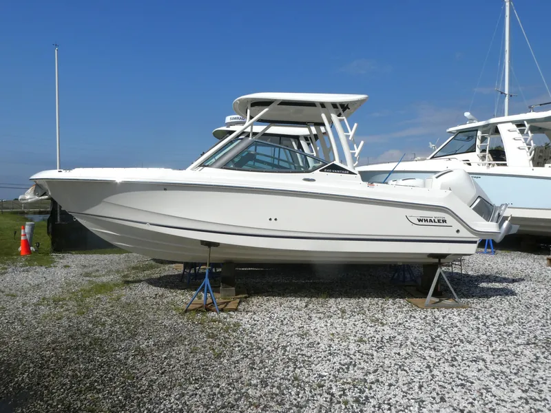 The Image of 2025 Boston Whaler 240 Vantage boat displayed on gravel lot under clear blue sky. - 0