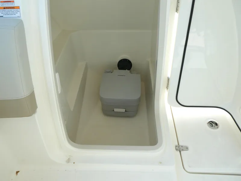 Slide: The Image of 2025 Boston Whaler 240 Vantage boat interior with portable toilet compartment. - 17