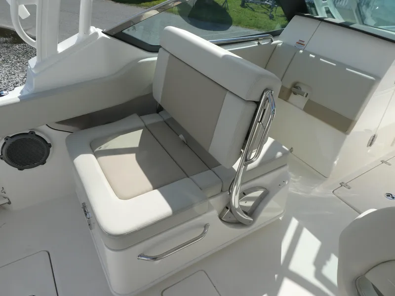 Slide: The Image of 2025 Boston Whaler 240 Vantage boat seat with beige cushions and stainless steel handles. - 8
