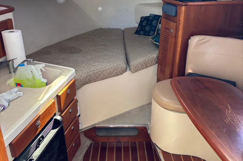 Slide: The Image of 2006 Pursuit 3370 Offshore cabin interior with bed, kitchenette, and seating area. - 10
