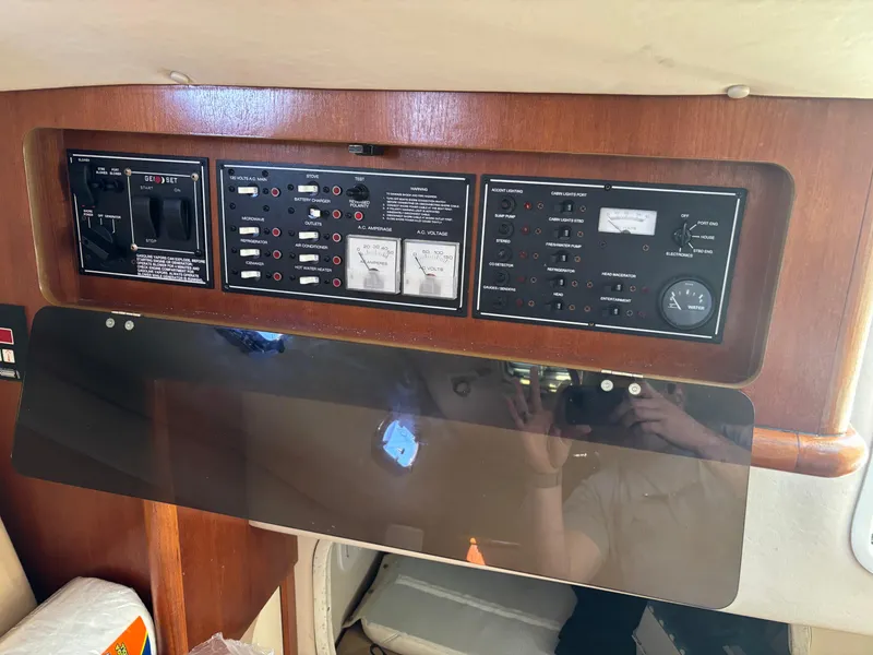 Slide: The Image of Control panel inside 2006 Pursuit 3370 Offshore boat, featuring various switches and gauges. - 12