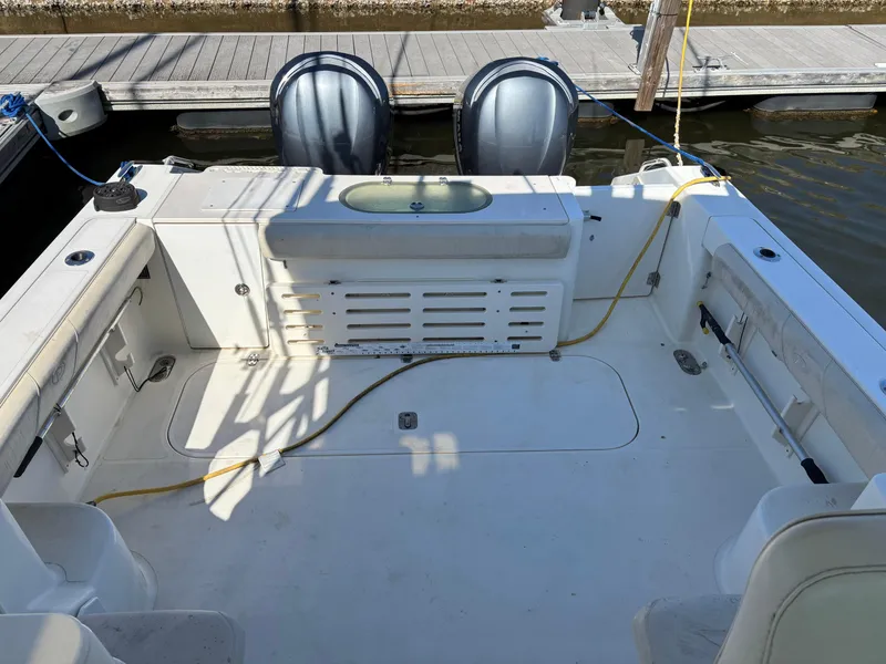 Slide: The Image of 2006 Pursuit 3370 Offshore boat deck with twin engines, docked at marina. - 13