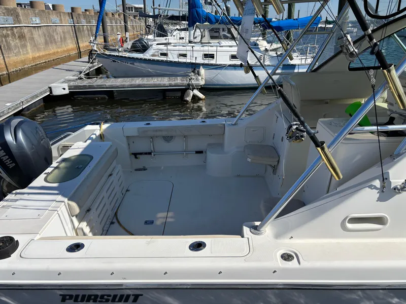 Slide: The Image of 2006 Pursuit 3370 Offshore boat docked, featuring spacious deck and fishing rod holders. - 15