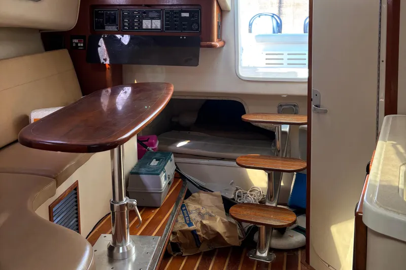 Slide: The Image of Interior of 2006 Pursuit 3370 Offshore boat with wooden table and steps. - 16