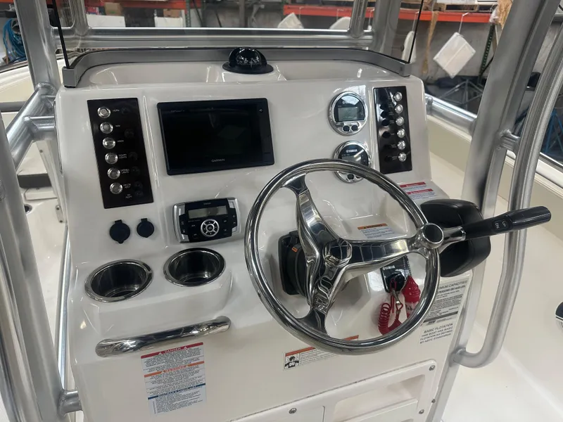 Slide: The Image of 2019 Robalo R222 Center Console boat dashboard with steering wheel and controls. - 12