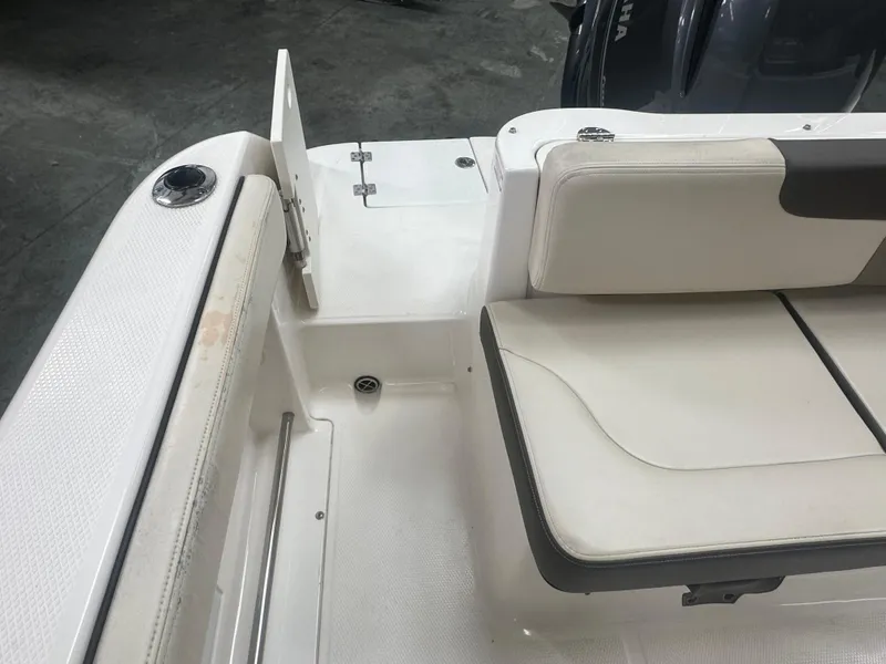 Slide: The Image of 2019 Robalo R222 Center Console boat interior with white seating and storage area. - 16