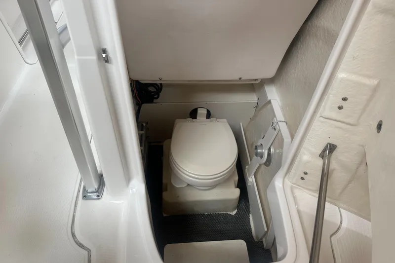 Slide: The Image of 2019 Robalo R222 Center Console boat interior with compact marine toilet. - 26