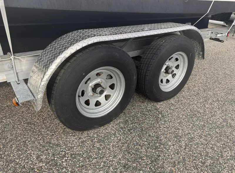 Slide: The Image of Trailer wheels for 2019 Robalo R222 Center Console boat on asphalt. - 29