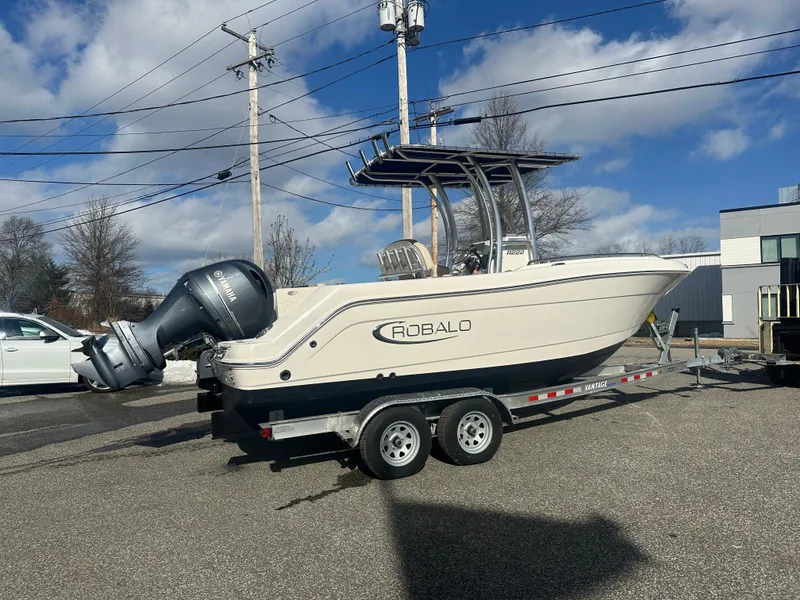 Slide: The Image of 2019 Robalo R222 Center Console boat on trailer, parked outdoors under blue sky. - 3
