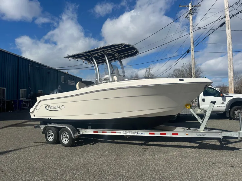 Slide: The Image of 2019 Robalo R222 Center Console boat on trailer, parked outdoors under blue sky. - 4