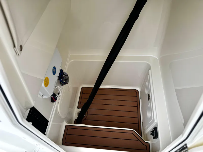 Slide: The Image of Interior of 2025 Pathfinder 2400TRS boat, featuring storage compartment with wooden flooring. - 13