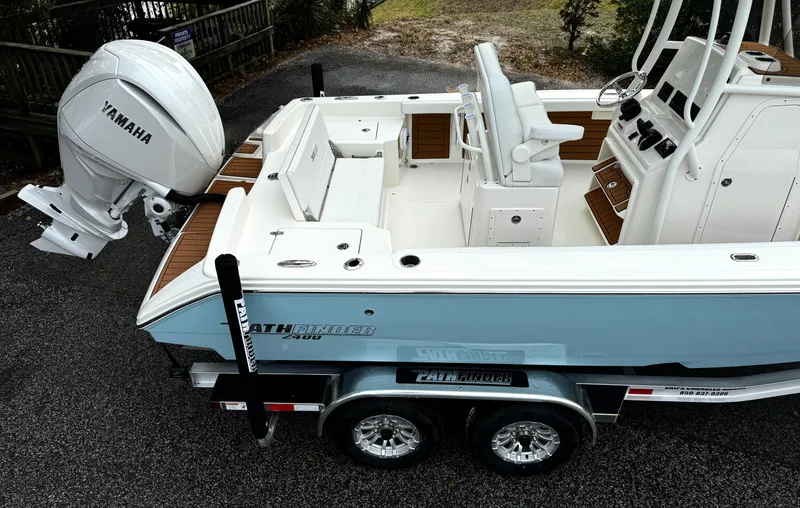 Slide: The Image of 2025 Pathfinder 2400TRS boat with Yamaha engine on trailer, showcasing interior and controls. - 4