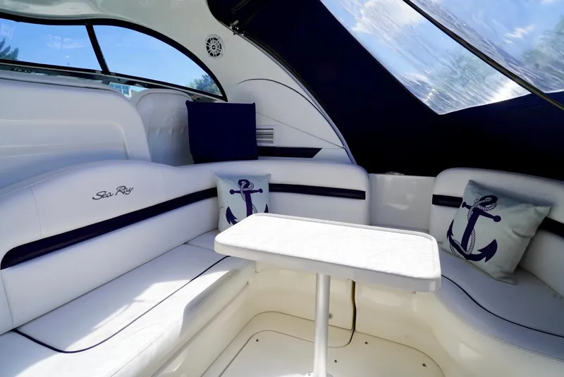 Slide: The Image of Interior of 2010 Sea Ray 390 Sundancer with white seating and nautical-themed cushions. - 15