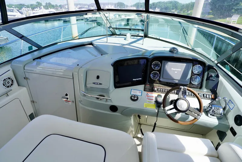 Slide: The Image of 2010 Sea Ray 390 Sundancer helm with modern navigation equipment and comfortable seating. - 19