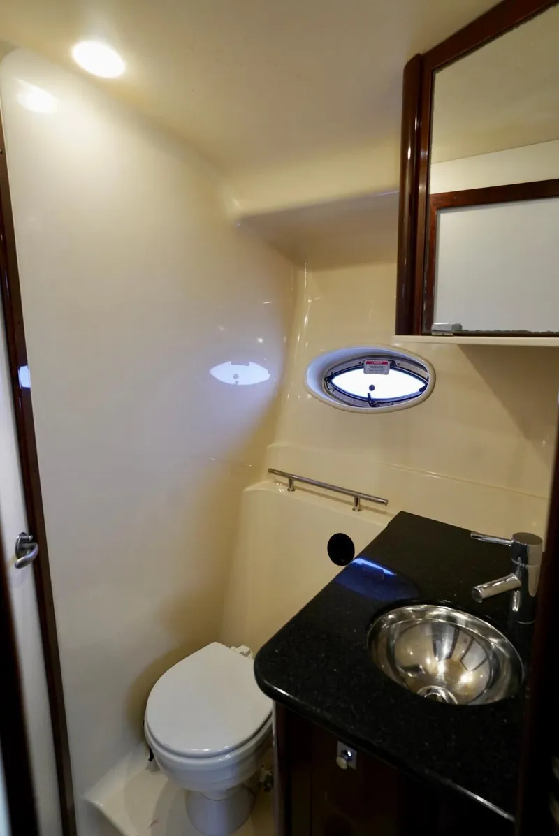 Slide: The Image of 2010 Sea Ray 390 Sundancer bathroom with sink, toilet, and porthole window. - 23