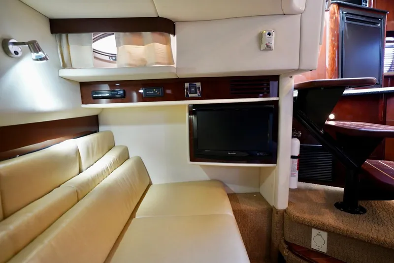 Slide: The Image of Interior of 2010 Sea Ray 390 Sundancer with beige seating and built-in TV. - 29