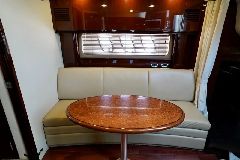 Slide: The Image of Interior of 2010 Sea Ray 390 Sundancer with beige seating and wooden table. - 30