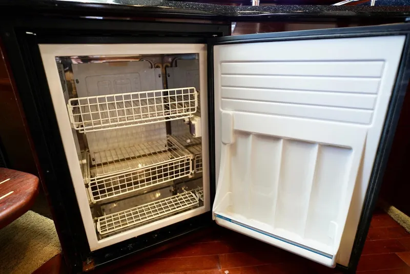 Slide: The Image of Open refrigerator with wire shelves inside a 2010 Sea Ray 390 Sundancer yacht. - 31