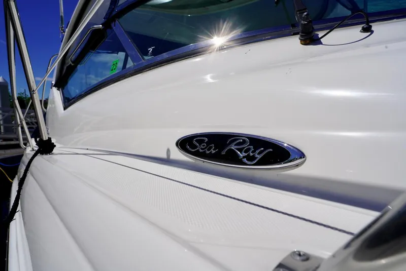 Slide: The Image of Sea Ray 390 Sundancer 2010 boat, close-up of logo and sleek white exterior. - 39