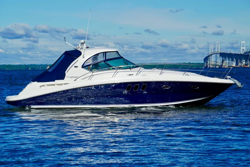 Slide: The Image of 2010 Sea Ray 390 Sundancer yacht cruising on open water near a bridge. - 4