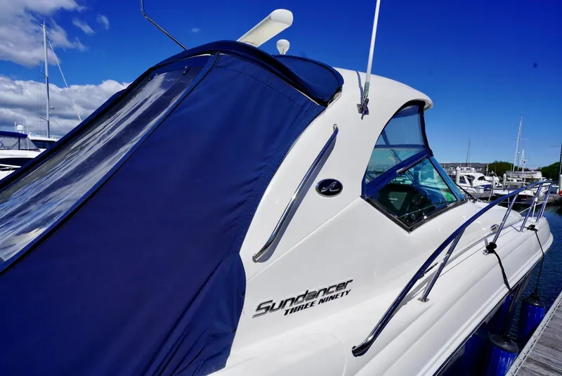 Slide: The Image of 2010 Sea Ray 390 Sundancer yacht docked, featuring sleek design and blue canopy. - 41