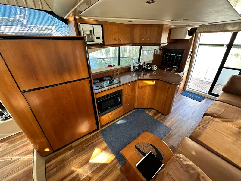 Slide: The Image of Luxurious 1999 Cruisers 5000 Sedan Sport yacht interior with modern kitchen and cozy seating area. - 5