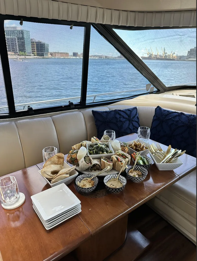 Slide: The Image of Luxurious 1999 Cruisers 5000 Sedan Sport yacht interior with elegant dining setup by the waterfront. - 7