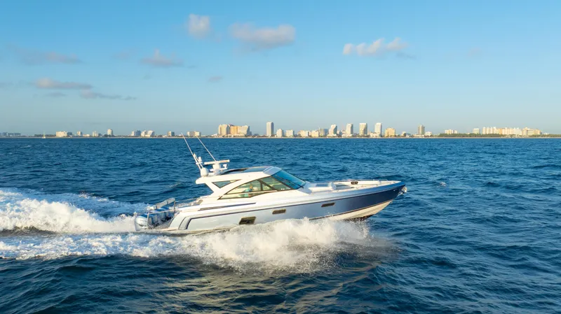 Slide: The Image of 2018 Formula 430 Super Sport Crossover yacht cruising on open water with city skyline backdrop. - 34