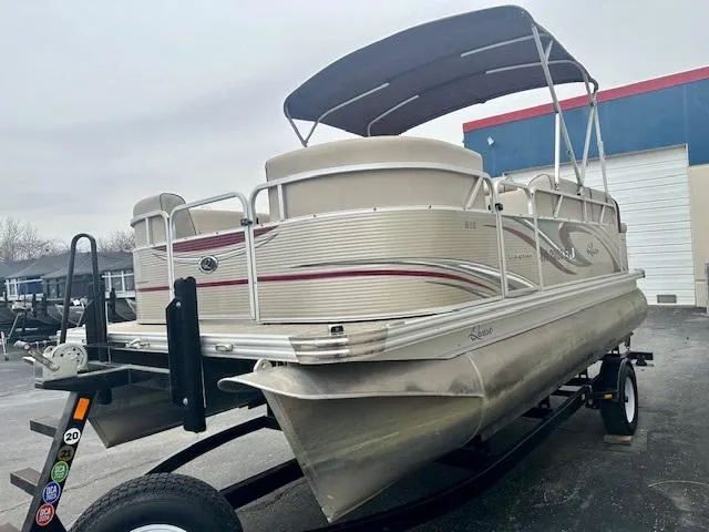 Slide: The Image of 2019 Qwest 818 pontoon boat on trailer with canopy, parked outdoors. - 3
