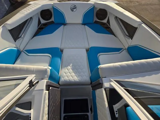 Slide: The Image of 2025 Tigé 24RZX boat interior with blue and white seating, featuring modern design and spacious layout. - 2