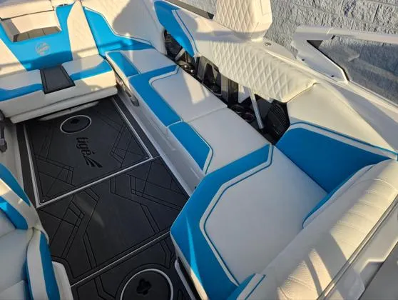 Slide: The Image of 2025 Tigé 24RZX boat interior with blue and white seating, modern design, and logo flooring. - 8