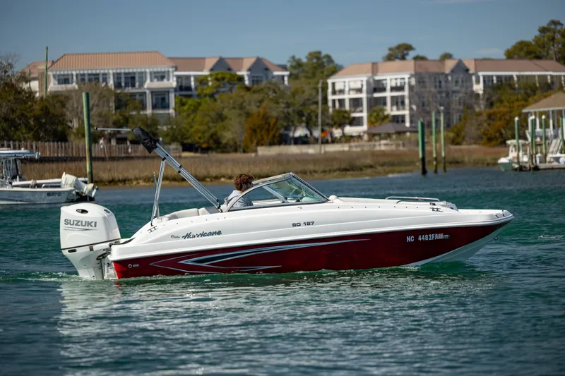 Slide: The Image of 2023 Hurricane SunDeck 187 OB boat cruising on a scenic waterway. - 3