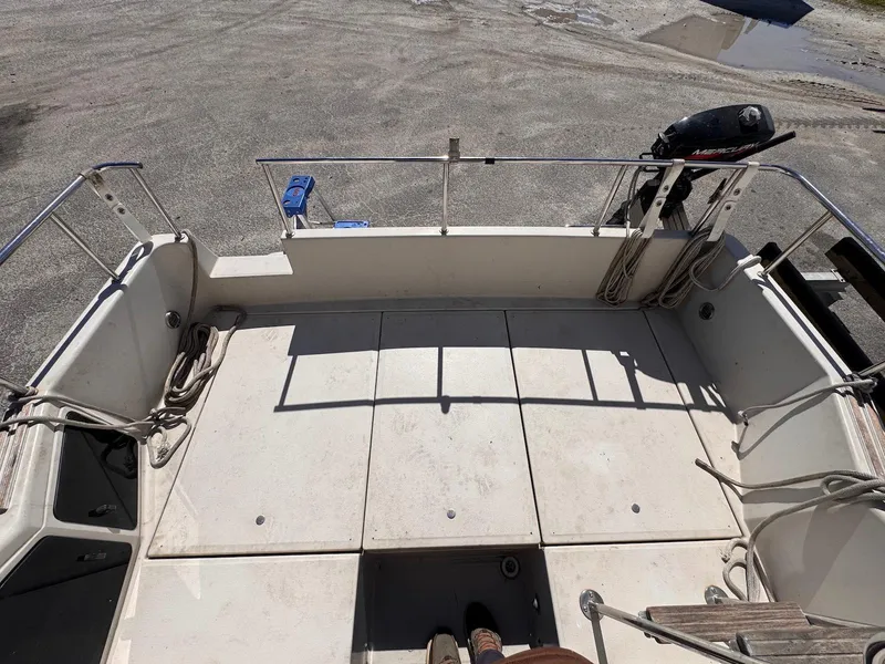 Slide: The Image of 1988 Sea Ray 265 Sedan Bridge boat deck with railing and ropes. - 12