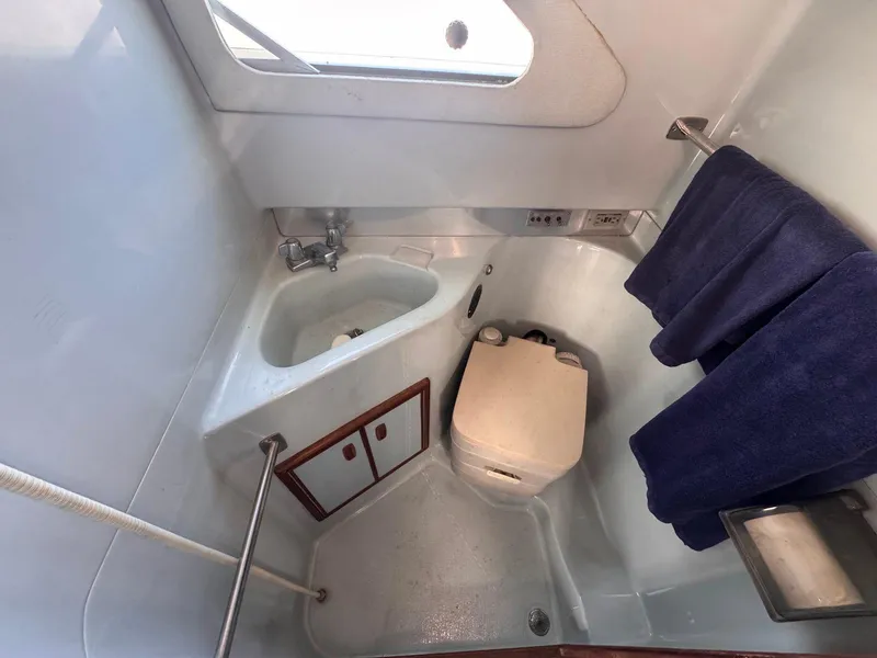 Slide: The Image of 1988 Sea Ray 265 Sedan Bridge bathroom with sink, toilet, and towel rack. - 15