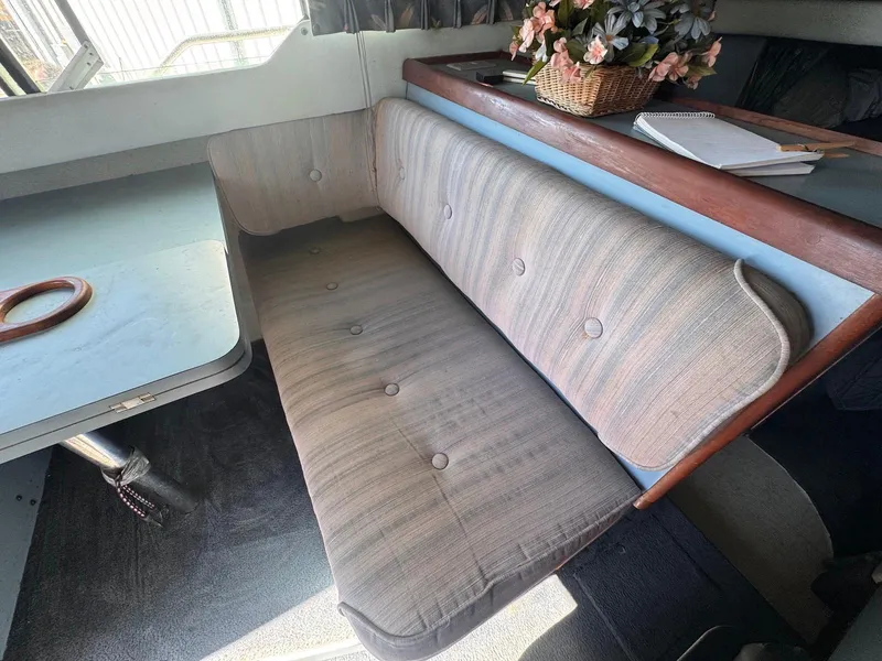 Slide: The Image of 1988 Sea Ray 265 Sedan Bridge interior with cushioned seating and table. - 19