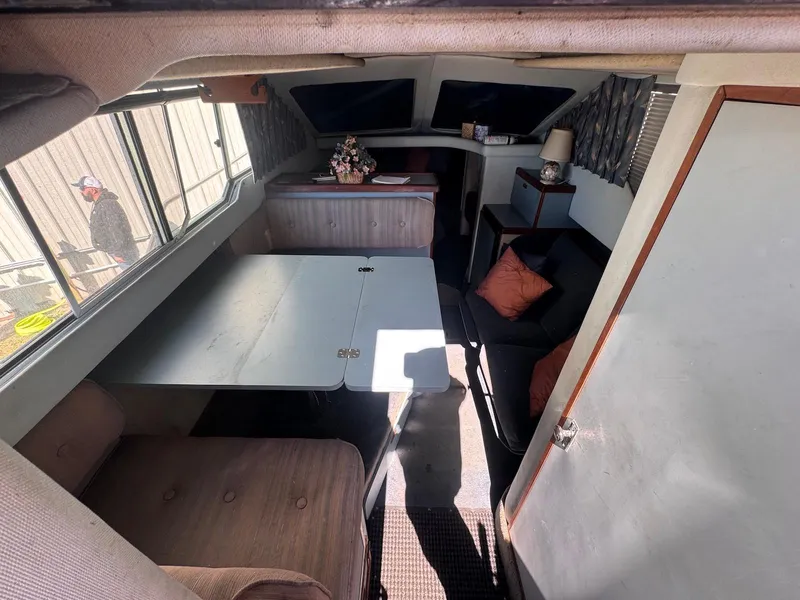 Slide: The Image of Interior of 1988 Sea Ray 265 Sedan Bridge with seating and table. - 21