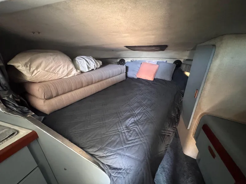 Slide: The Image of Cozy cabin interior of 1988 Sea Ray 265 Sedan Bridge with bed and pillows. - 28