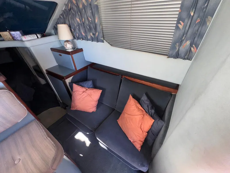 Slide: The Image of Interior of 1988 Sea Ray 265 Sedan Bridge with cozy seating and decorative pillows. - 29
