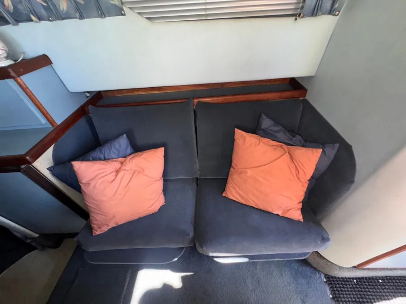 Slide: The Image of Interior of 1988 Sea Ray 265 Sedan Bridge with cozy seating and colorful cushions. - 30