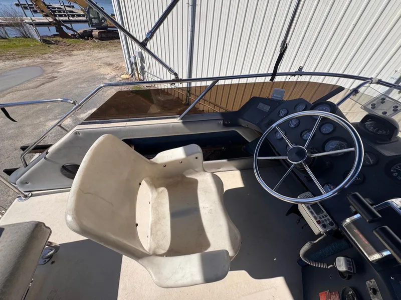 Slide: The Image of 1988 Sea Ray 265 Sedan Bridge helm with steering wheel and captain's chair. - 35