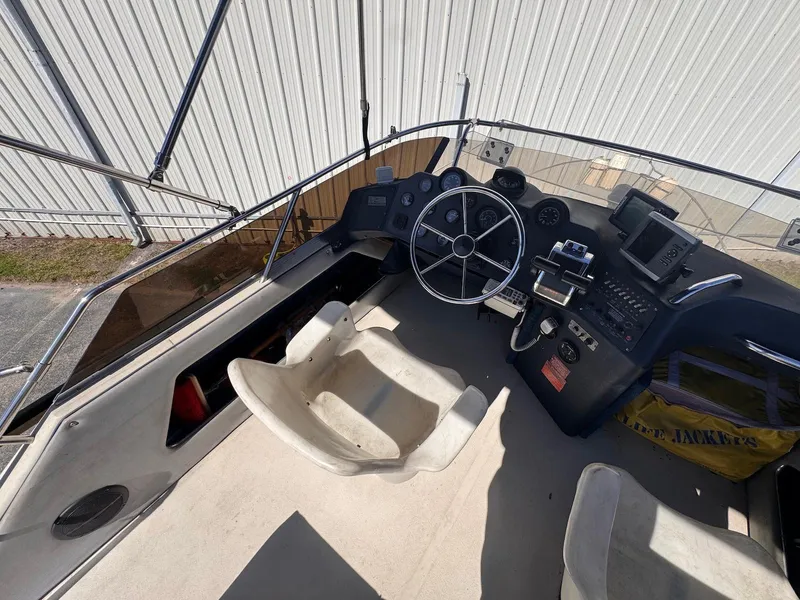 Slide: The Image of 1988 Sea Ray 265 Sedan Bridge helm with steering wheel and navigation equipment. - 36