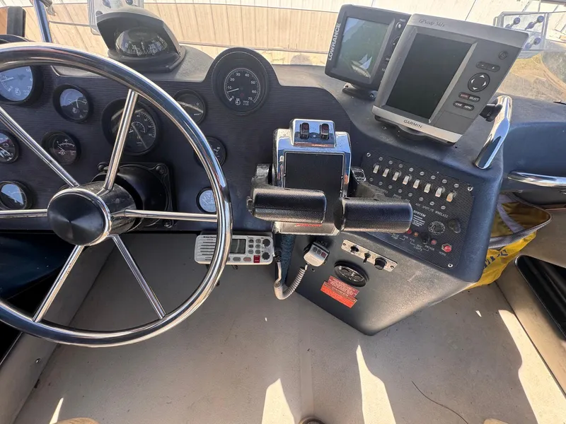 Slide: The Image of Dashboard of a 1988 Sea Ray 265 Sedan Bridge boat with steering wheel and navigation equipment. - 39