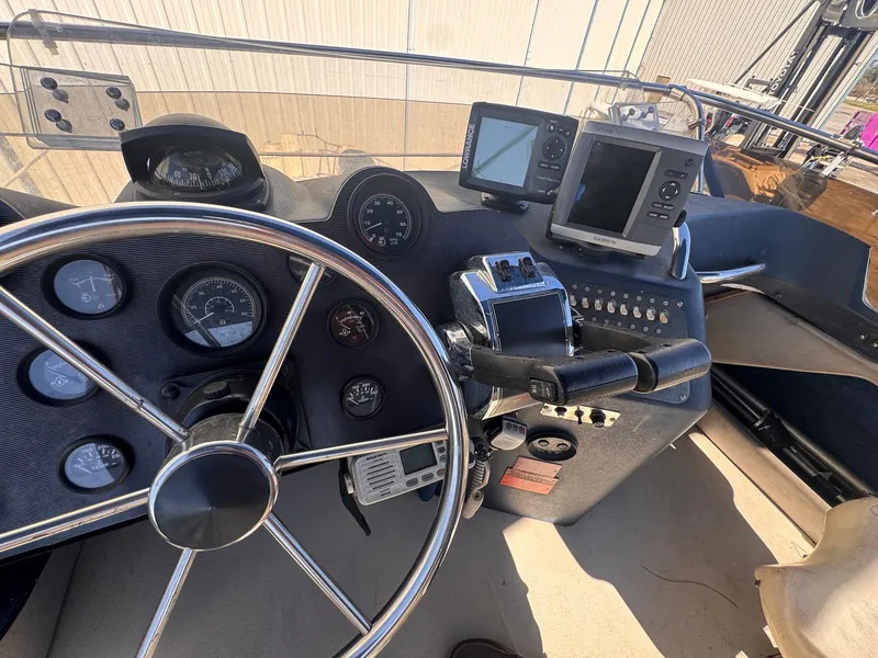 Slide: The Image of 1988 Sea Ray 265 Sedan Bridge helm with steering wheel, gauges, and navigation equipment. - 41