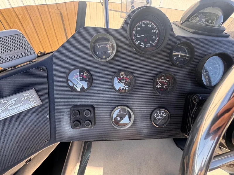 Slide: The Image of Dashboard of a 1988 Sea Ray 265 Sedan Bridge boat with various gauges and controls. - 42