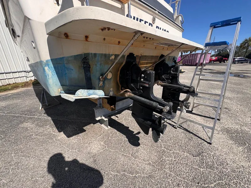 Slide: The Image of 1988 Sea Ray 265 Sedan Bridge boat stern with dual outboard motors on dry land. - 5