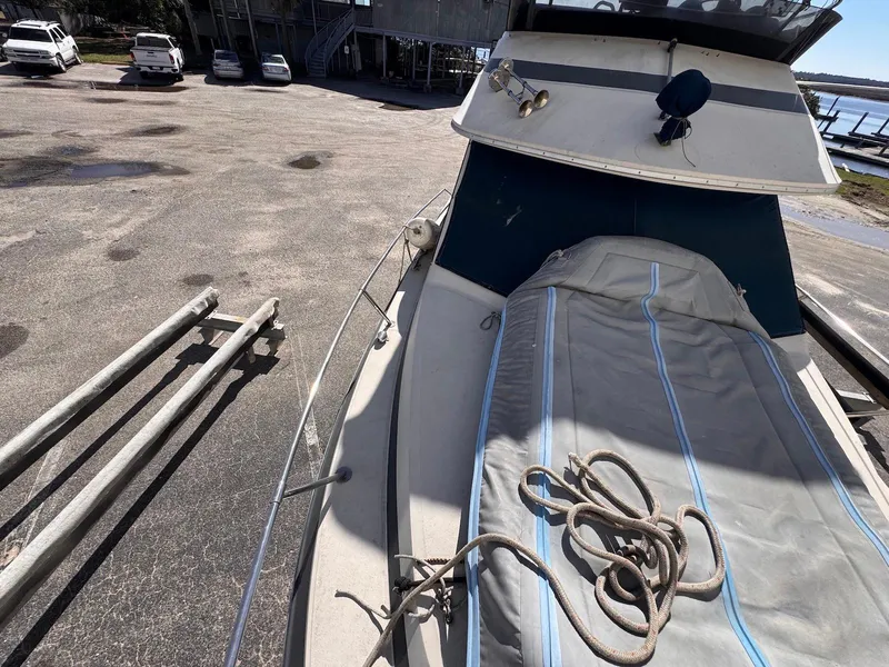 Slide: The Image of 1988 Sea Ray 265 Sedan Bridge boat on dry dock with cover and rope. - 7