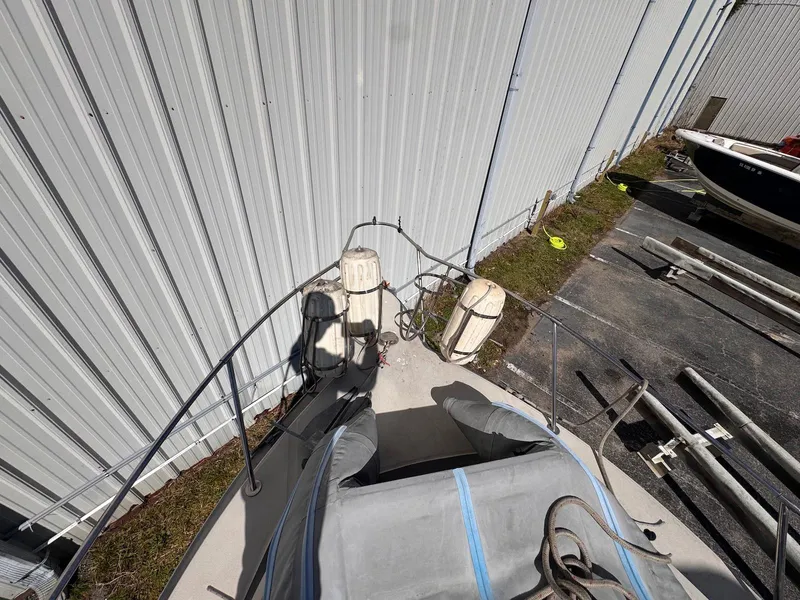 Slide: The Image of 1988 Sea Ray 265 Sedan Bridge boat docked near a metal building. - 9