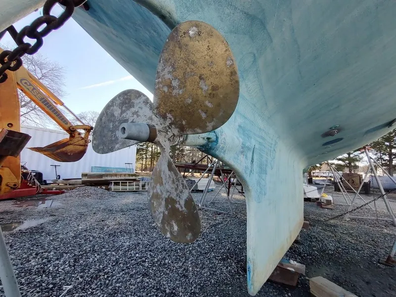 Slide: The Image of Propeller of 1977 Hallberg-Rassy 41 sailboat on dry dock, surrounded by equipment. - 12