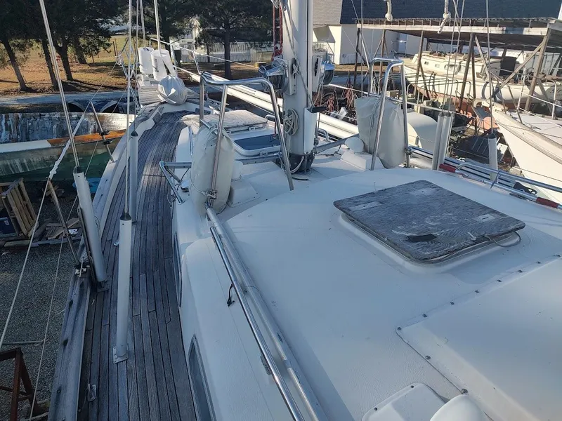 Slide: The Image of 1977 Hallberg-Rassy 41 sailboat deck with wooden flooring and rigging, docked in a marina. - 18